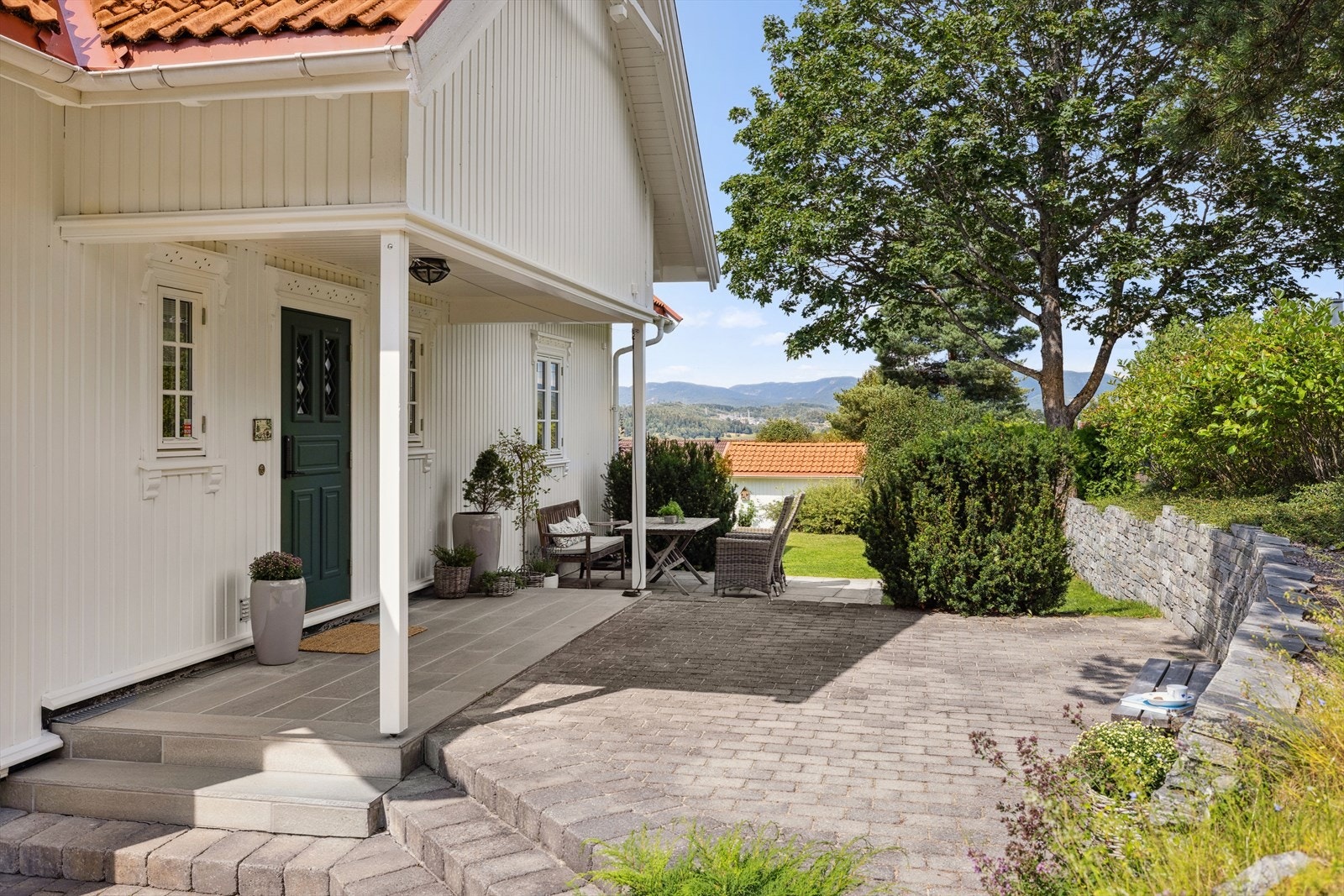 Innbydende overbyget inngangsparti med uteplass. Denne eiendommen er det virkelig lagt kjærlighet i med utsmykkinger og kvalitetsinnredninger. Galleribilde