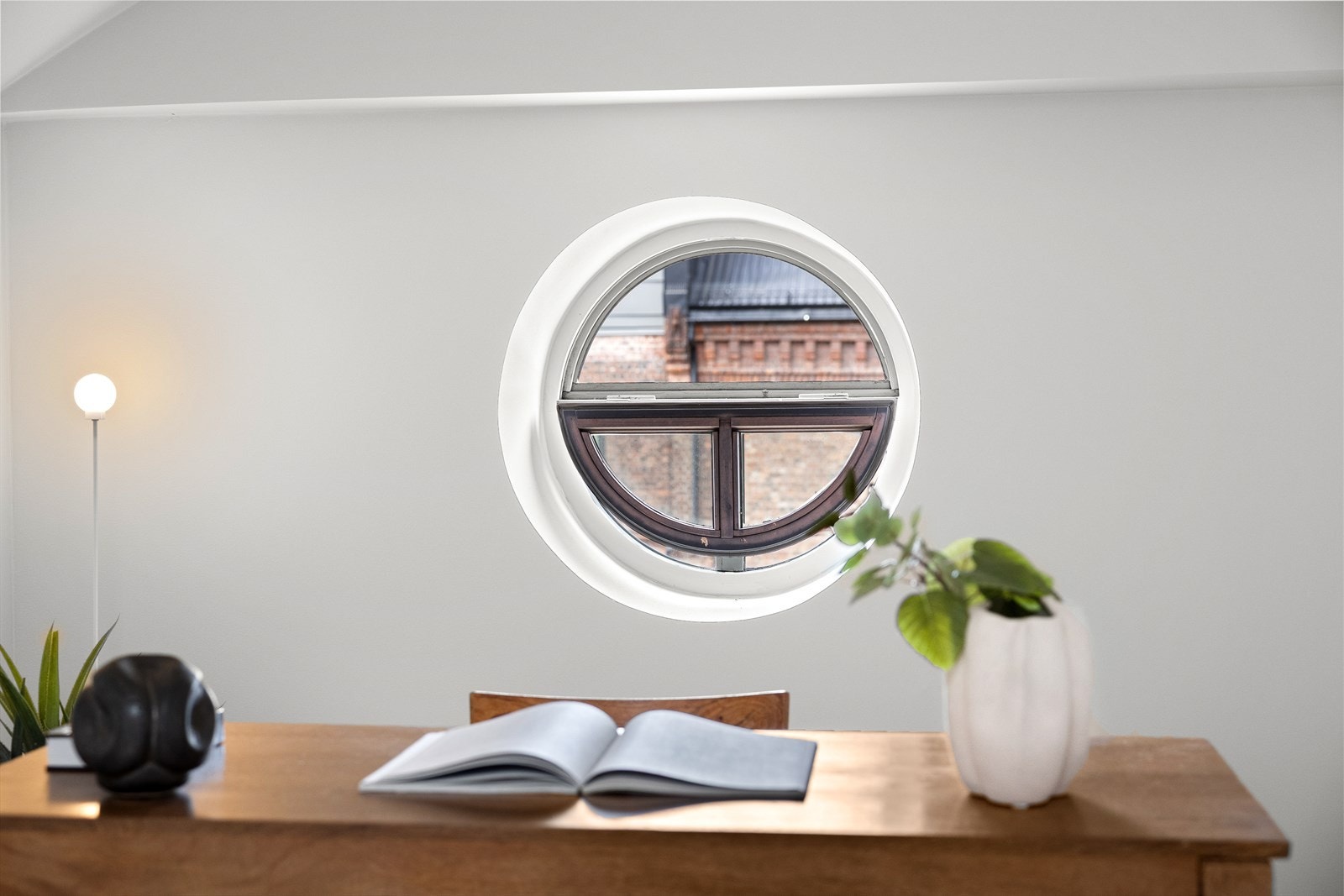 Unikt rundt vindu som gir rommet et visuelt særpreg Galleribilde