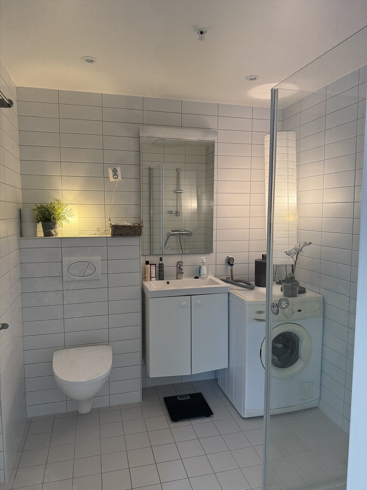 Stort bad med vaskemaskin, oppbevaringsplass, toalett og dusj Galleribilde