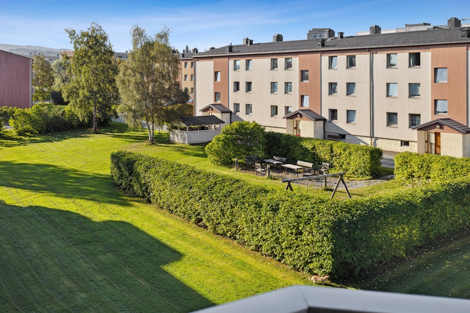 Utsikt fra balkongen ut mot borettslagets fine fellesarealer. Galleribilde