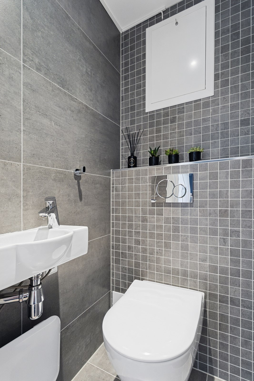 Ved entréen er det et flislagt toalettrom på ca. 1 m² med vegghengt wc og servant. Galleribilde