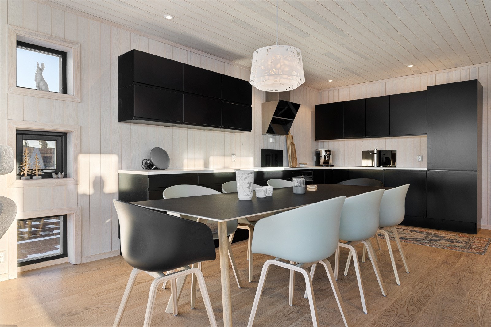 Moderne kjøkken med integrerte hvitevarer som induksjonsplate, ventilator, komfyr, kombinert kjøl/frys og oppvaskmaskin Galleribilde