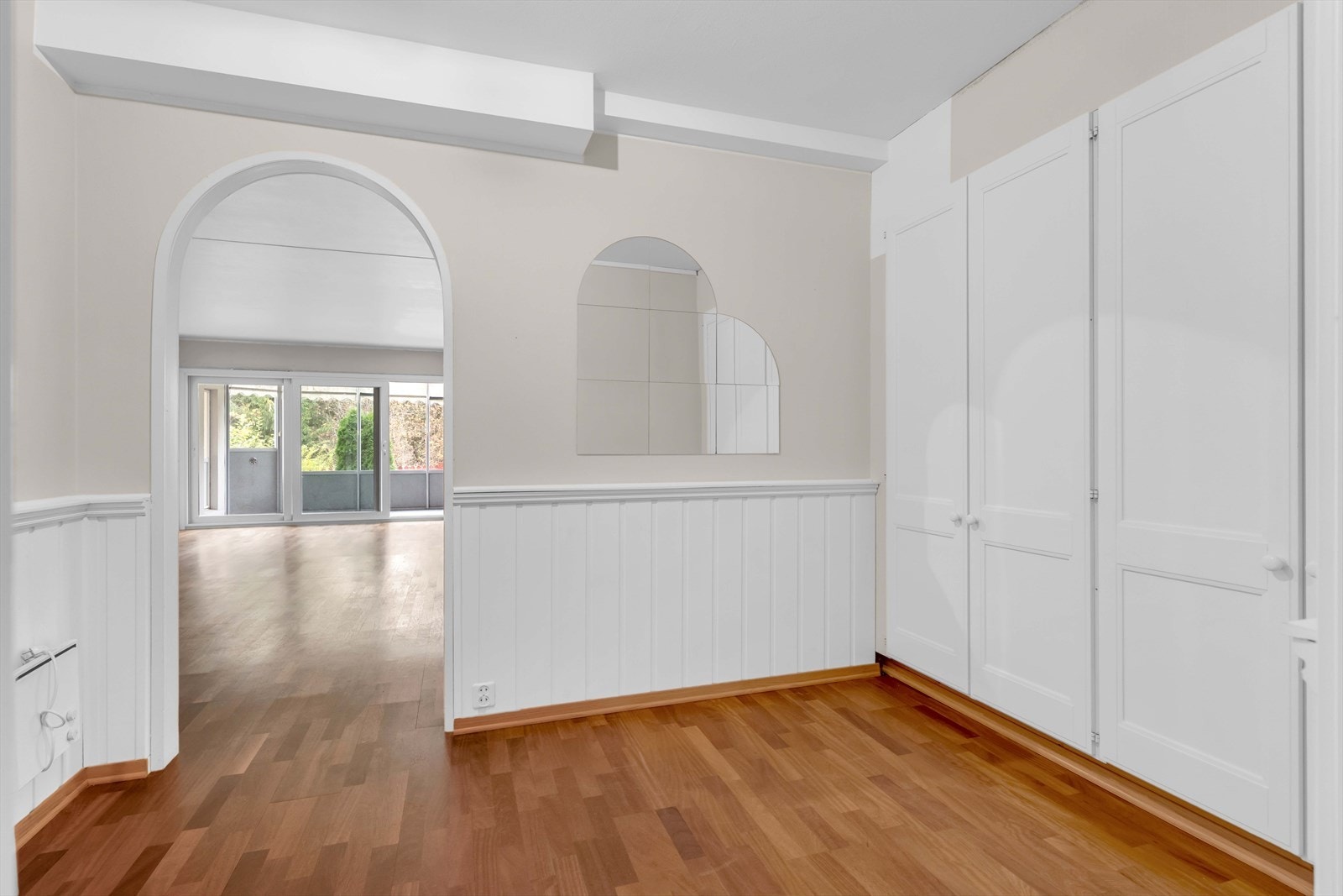 Her er det lysmalte overflater og gyllent parkettgulv, og langs én vegg er det en rekke med plassbygde garderobeskap. Galleribilde