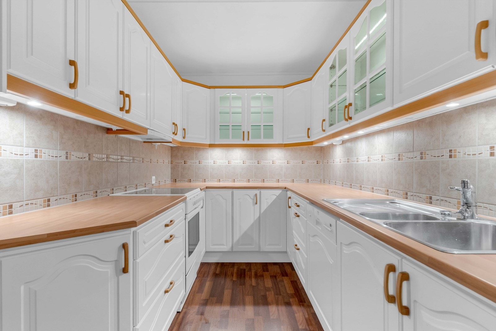 Veggene over benken er kledd med fliser, og under overskapene er det montert god arbeidsbelysning. Galleribilde