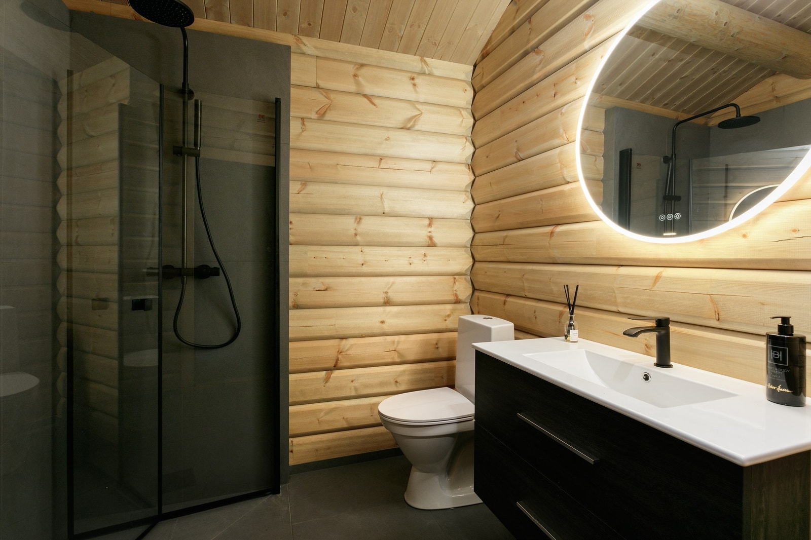 Flislagt gulv med gulvvarme, vegger i tømmer med flislagte vegger i dusjsonen. Dusjhjørne med foldbare glassvegger og vegghengt dusjarmatur med hånddusj og takdusj Galleribilde