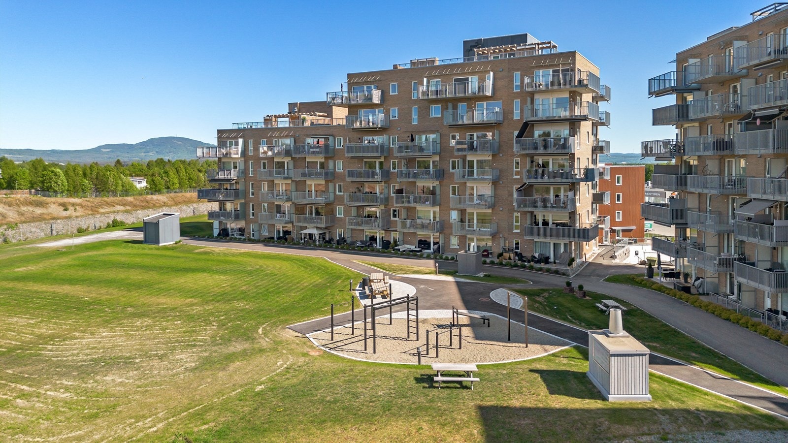 Leiligheten ligger på topp av blokka med navn "Perrongen". Uteområdende er pent opparbeidet med gressplen, sittebenker og en "tuftepark" for de som er glad i å trene. Galleribilde