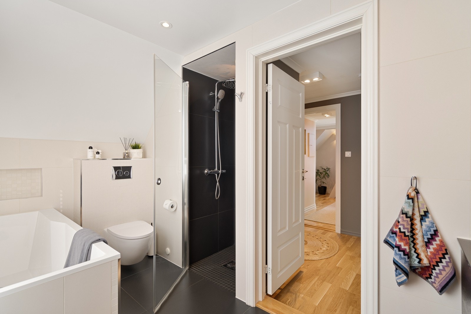 På badet er det både en dusjnisje og et innfliset badekar, der førstnevnte har regnfallsdusj og svingbar glassdør. Galleribilde