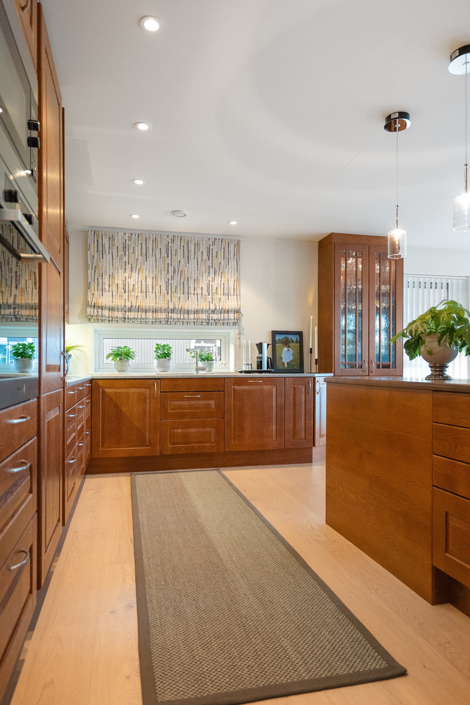 Kjøkkenet har eksklusiv innredning med profilerte fronter (noen med glass), samt stein- og heltrebenkeplater. Galleribilde