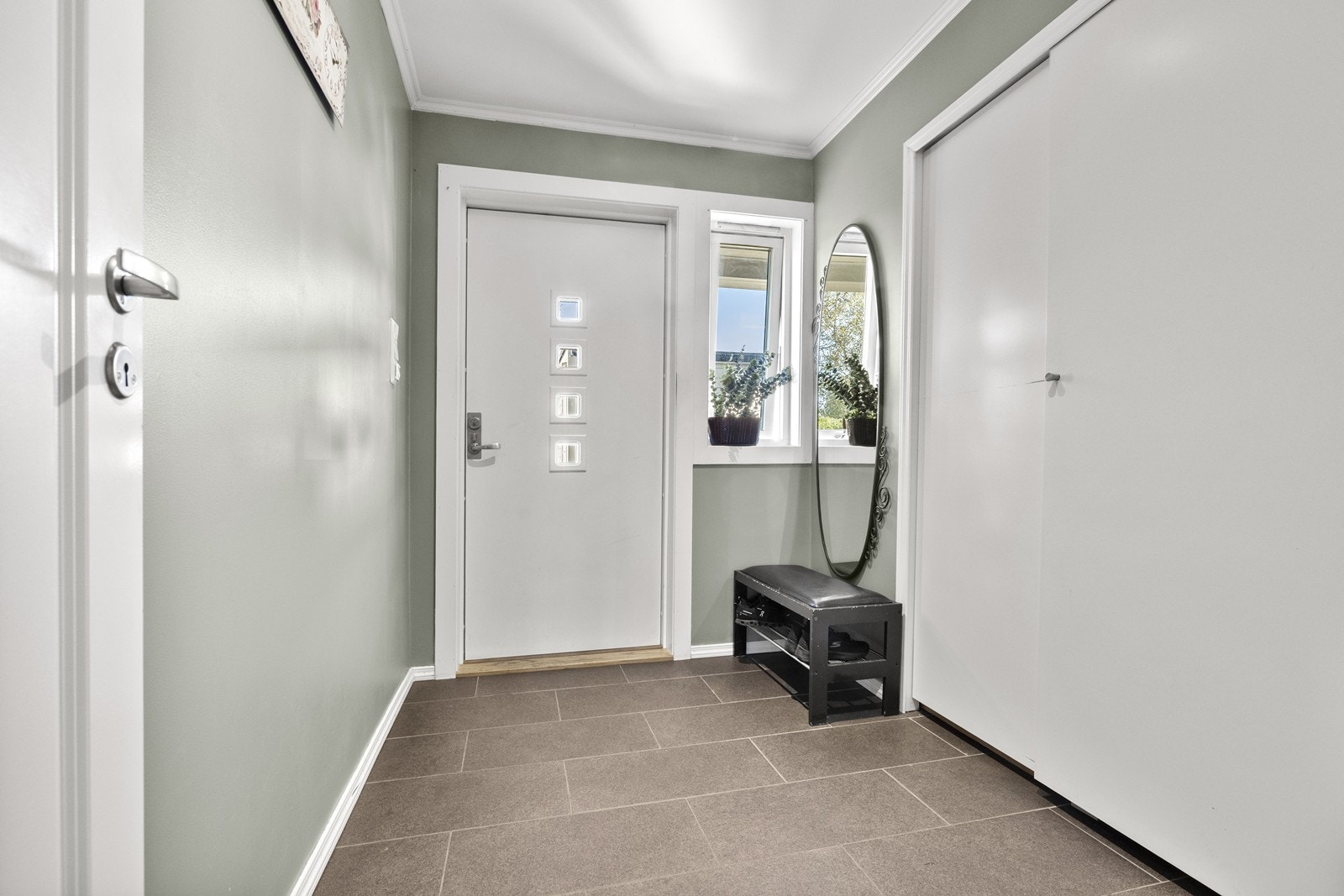 Velkommen inn i en lys og innbydende entré med slitesterke gulvfliser. Galleribilde
