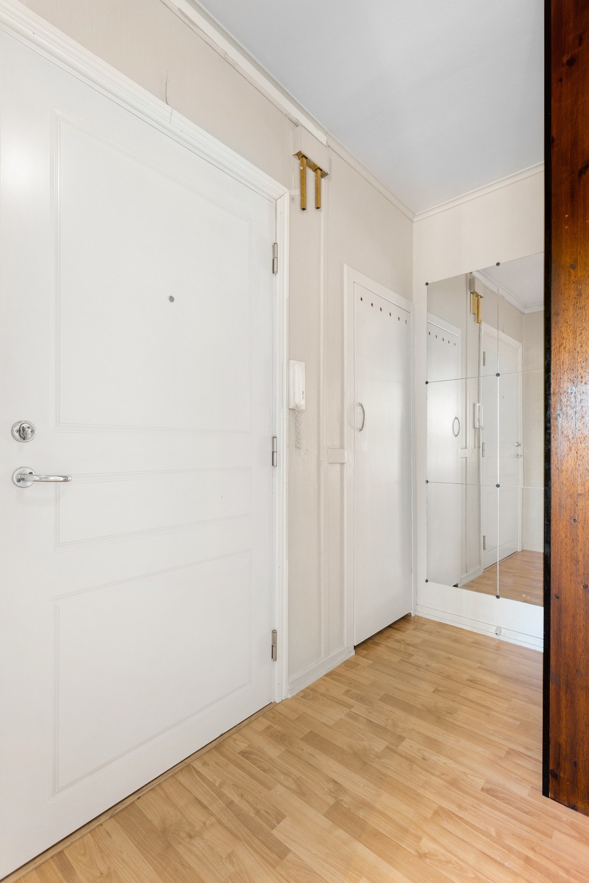 Entré med praktisk garderobeskap og kott. Det er montert porttelefon ved døren. Galleribilde