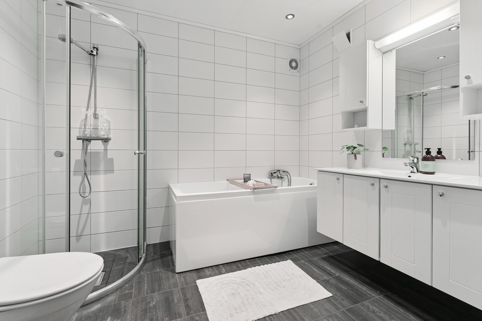 Bad frå 2009 i underetasje. Her har du flis på golv med varmekablar og baderomsplater på vegg. Av innreiing har du skapinnreiing med heilstøypt servant, badekar, vegghengt toalett og dusj på golv med skyvedørsinnreiing. Galleribilde