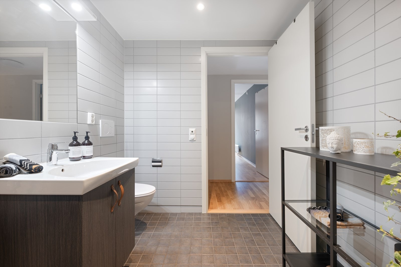 Baderommet er romslig og innbydende med vegghengt toalett, serventskap med speil over og dusjhjørne. Galleribilde