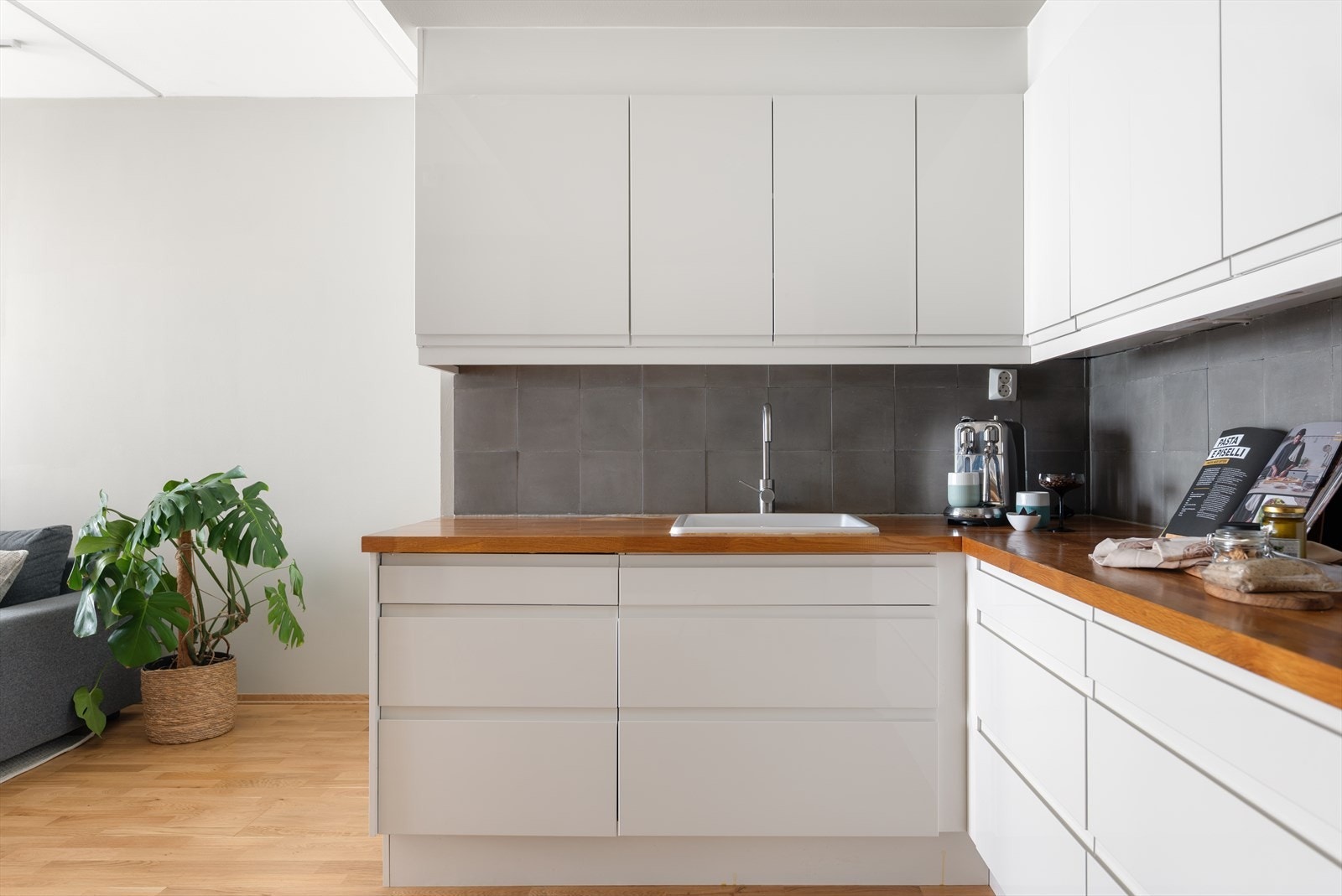 Solid, heltre benkeplate og flislagt vegg mellom skapene. Galleribilde