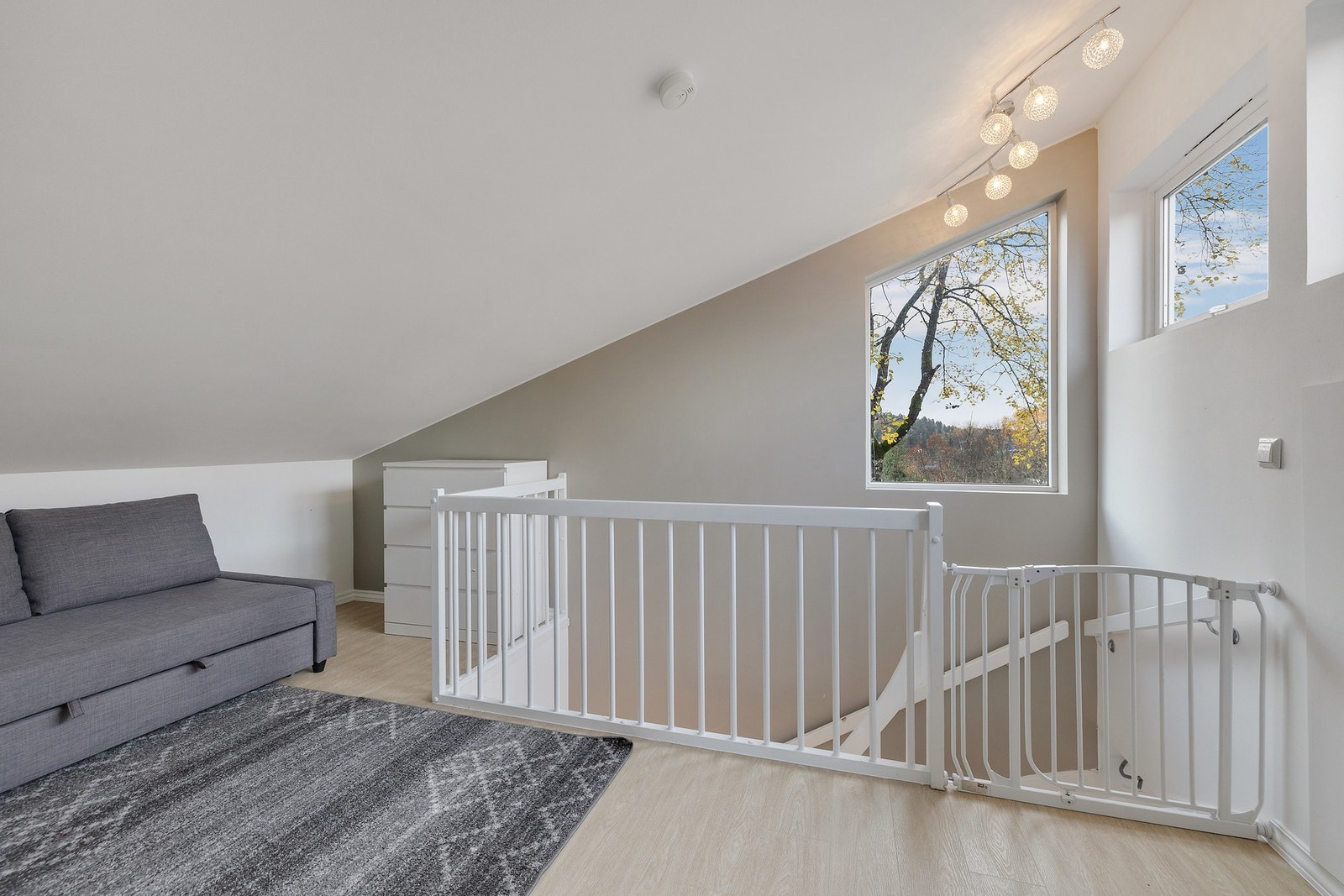 Lys loftstue med vindu og god plass til sittegruppe Galleribilde