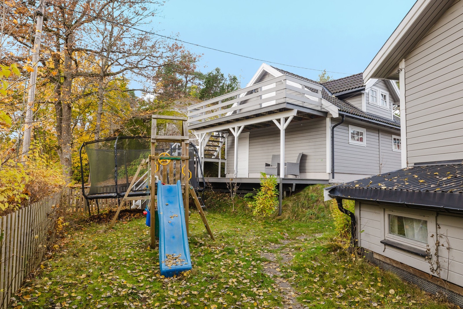 Tomten har en trivelig hage med plen og god plass til lek og opphold Galleribilde