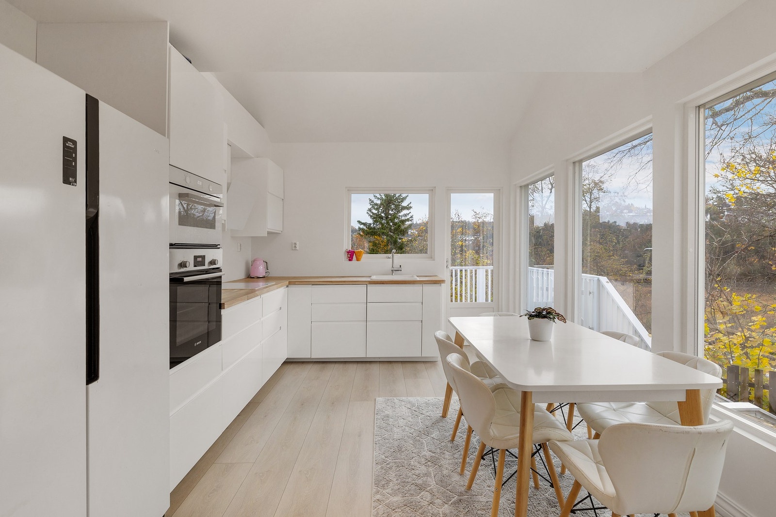 Lyst kjøkken fra 2020 med høyglans fronter og benkeplate i heltre med integrert servant og
platetopp.Integrerte hvitevarer med innfelt platetopp i benkeplate,oppvaskmaskin, komfyr og kjøl/frys Galleribilde