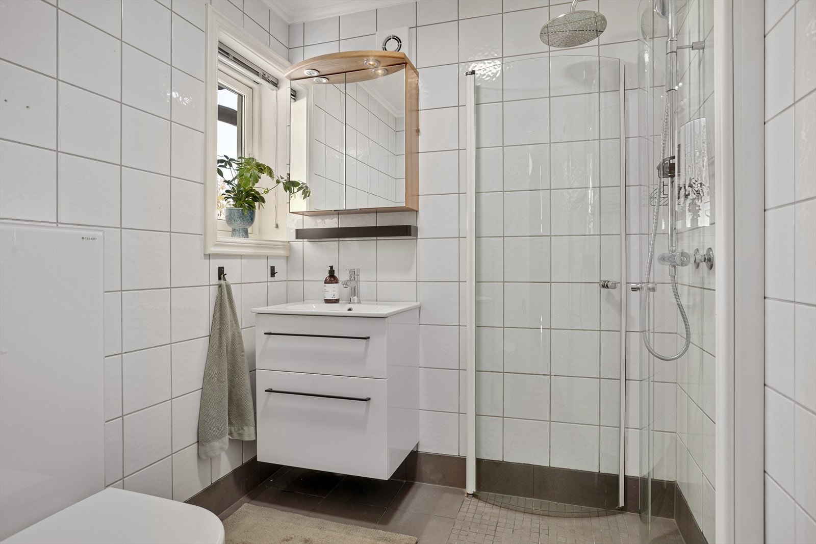 Delikat bad i 2. etasje med dusjhjørne, servant med skuffer, speil og wc. Galleribilde