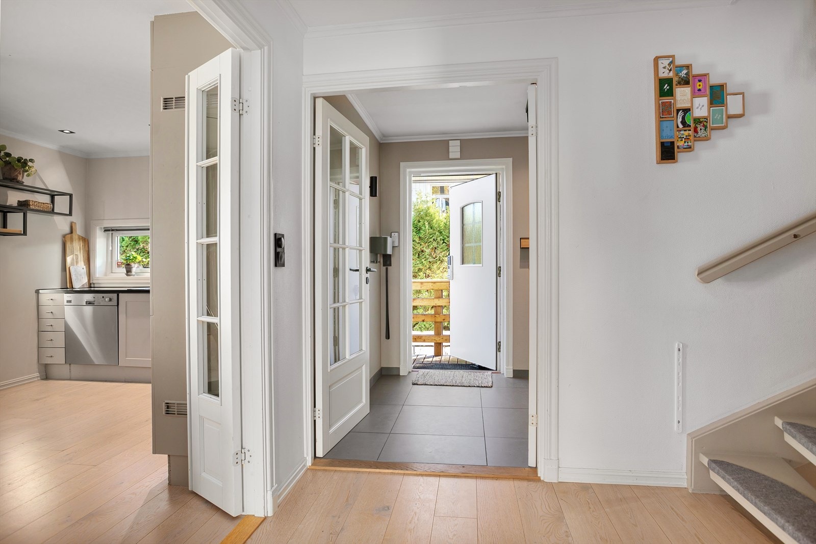 Flislagt entré med stor skyvedørsgarderobe med speilfronter. Galleribilde