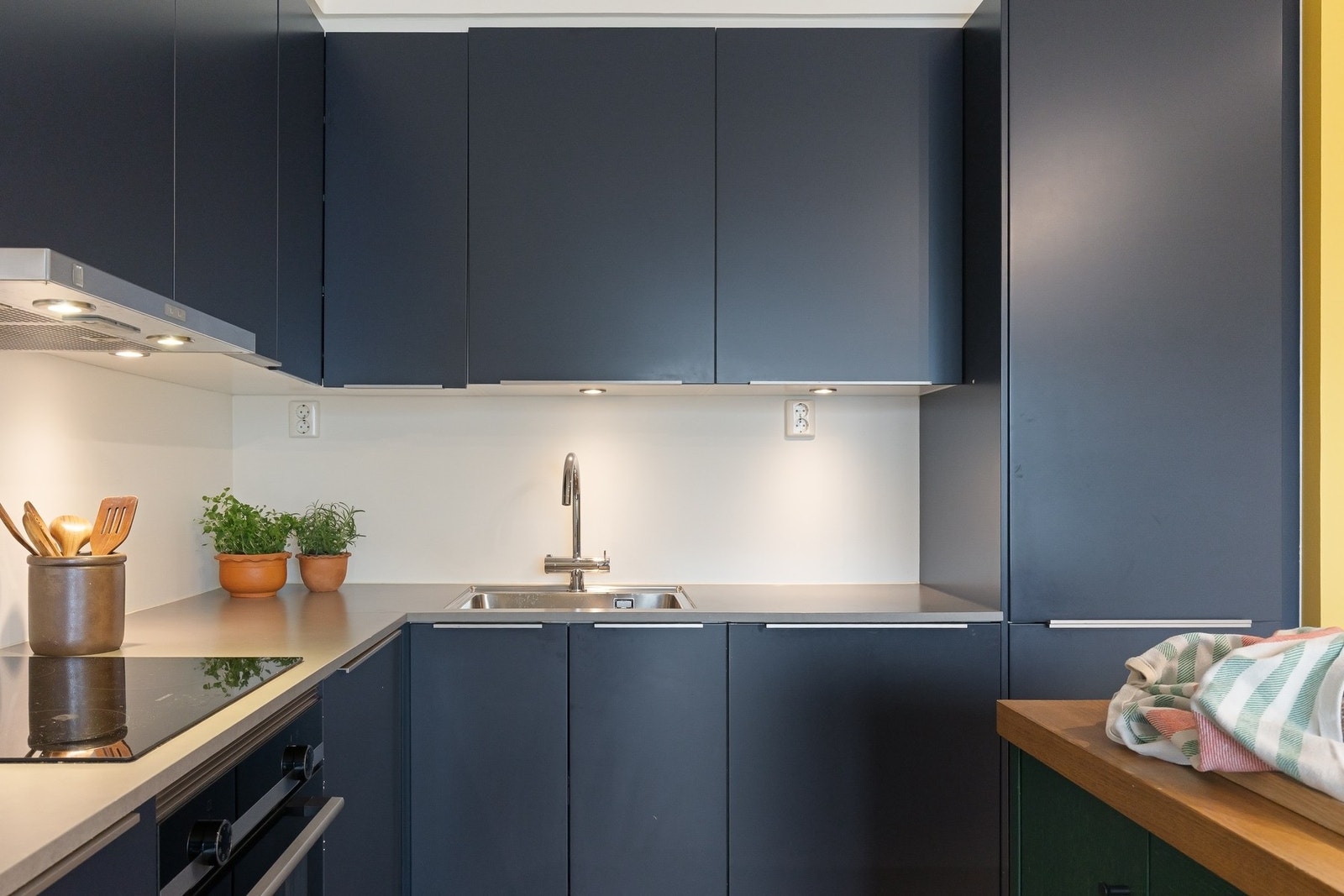 Integrerte hvitevarer som induksjonstopp, stekeovn, oppvaskmaskin og kjøl-/fryseskap sørger for en helhetlig og moderne stil. Galleribilde