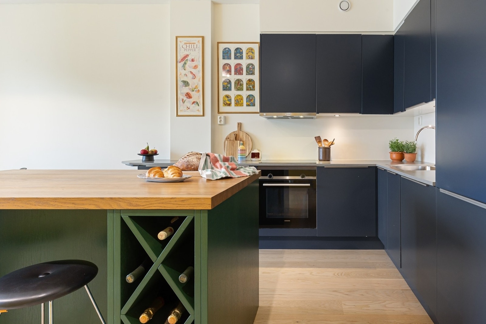 Kjøkkenet har en stilren, spesialdesignet kjøkkenøy med god arbeidsflate og smart oppbevaring. Galleribilde