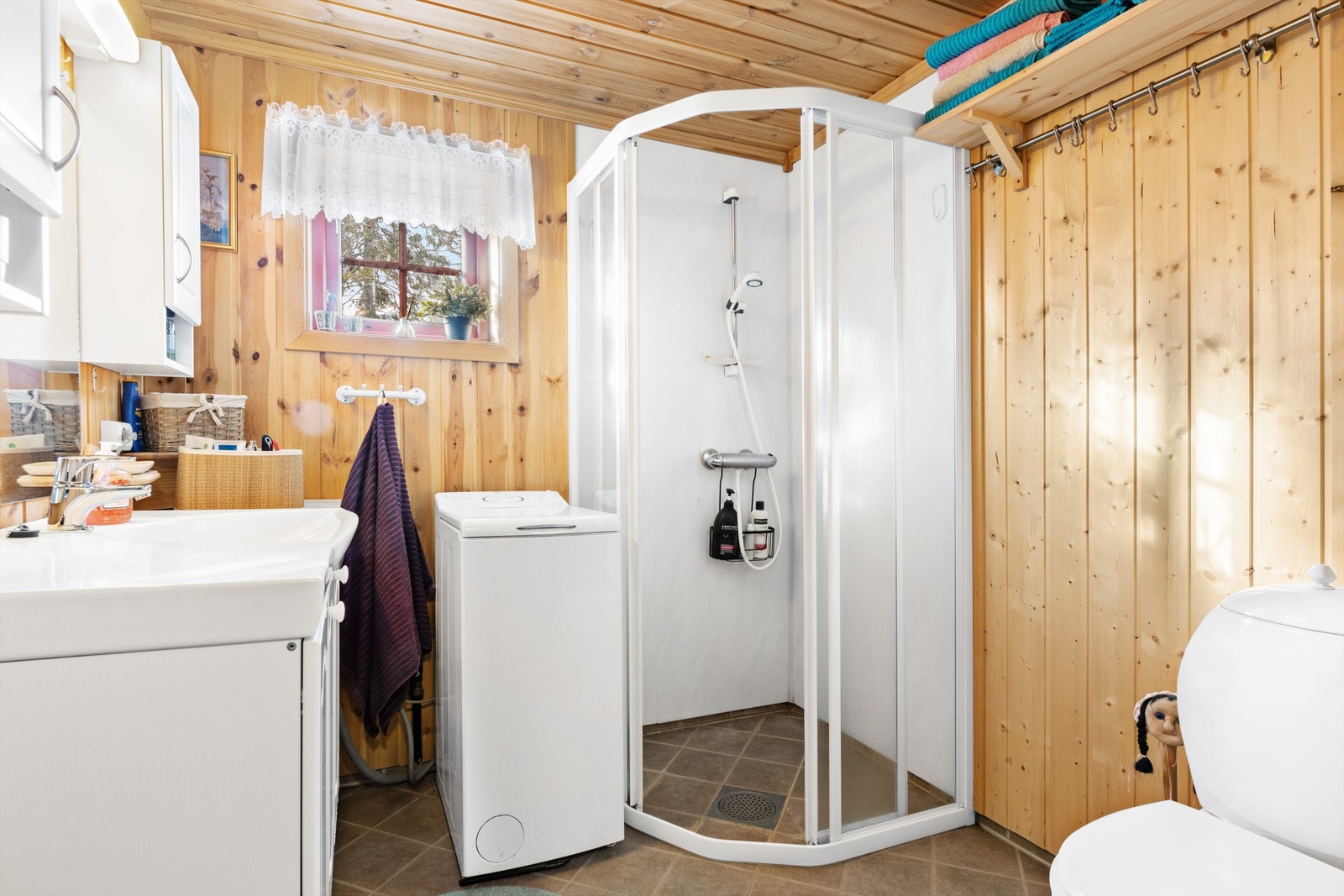 Pent hyttebad med fliser på gulv og panelte vegger Galleribilde