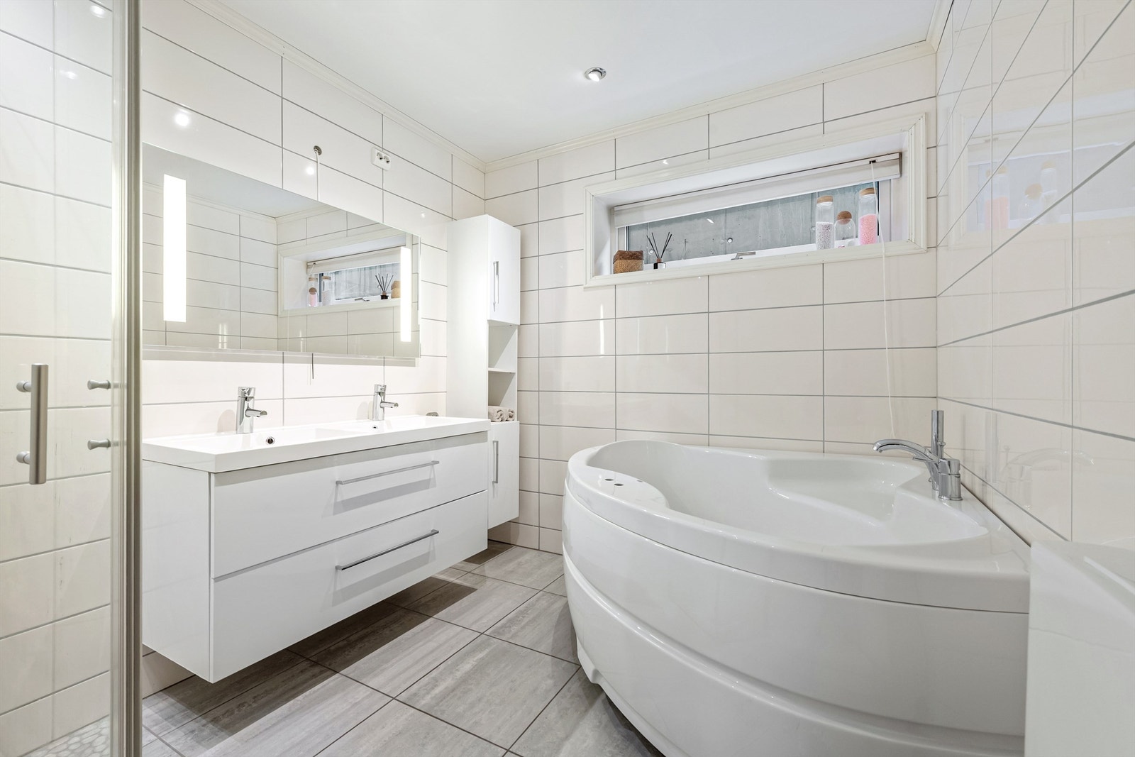 Flislagt bad i underetasje hjørnebadekar, dusjhjørne, wc og baderomsinnredning Galleribilde