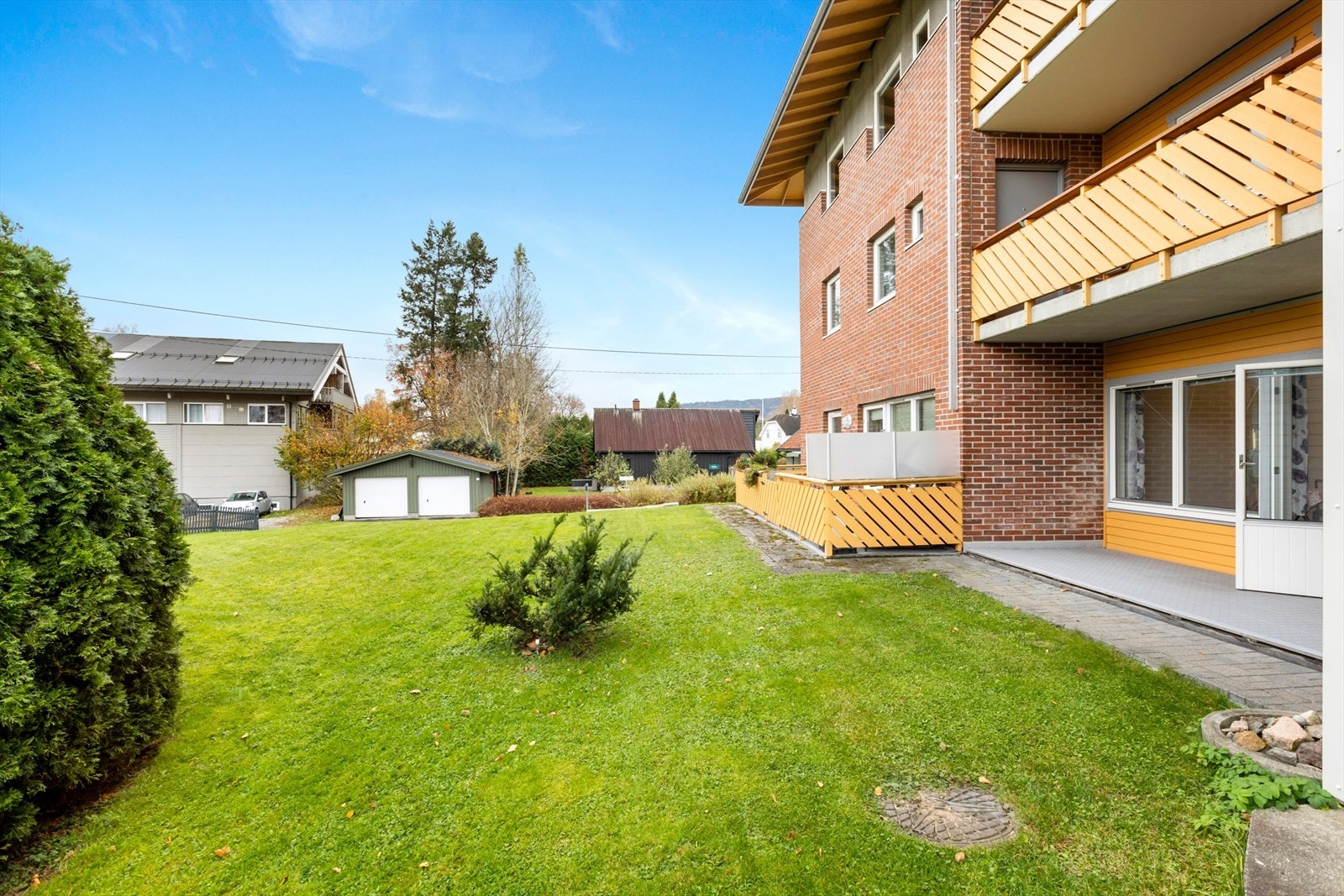 Tomten er opparbeidet med gressplen og busker. Galleribilde