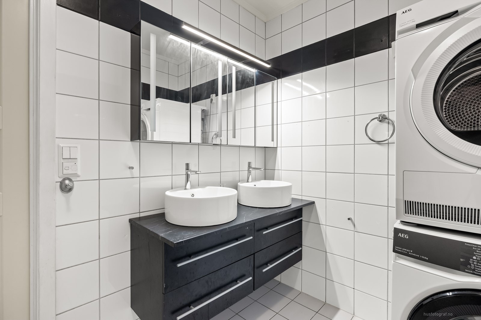 Badet har moderne bolleservant, speilskap, toalett og dusjhjørne. Det er opplegg for vaskemaskin. Galleribilde