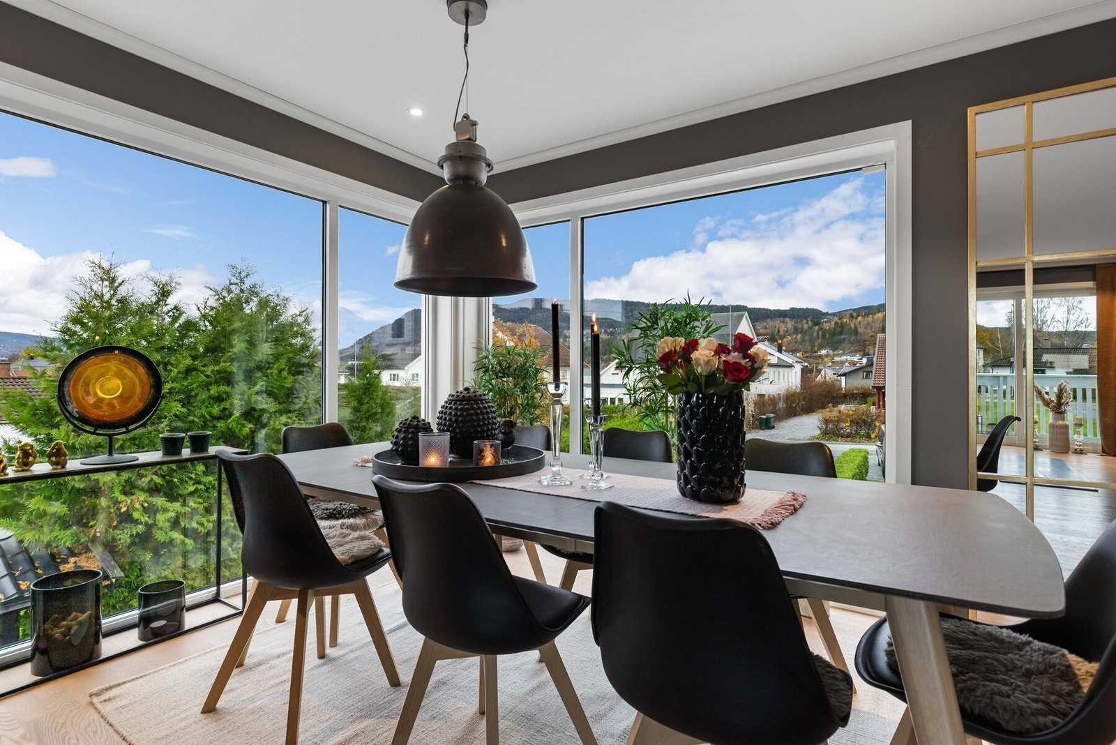 Stuen har store vindusflater på en side som bidrar til en flott utsikt fra middagsbordet. Galleribilde