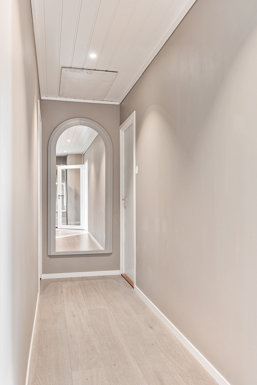 Gangen fungerer som et naturlig knutepunkt i boligen og leder videre til de øvrige rommene i etasjen. Galleribilde