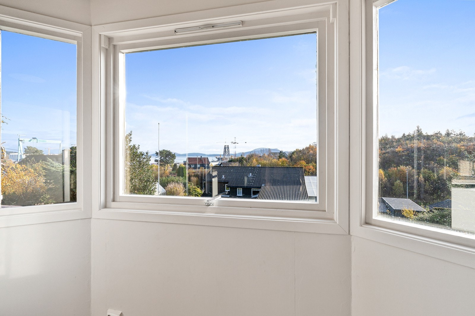 Fra karnappvinduene strømmer dagslyset inn og skaper et lyst og innbydende rom med fin utsikt. Galleribilde