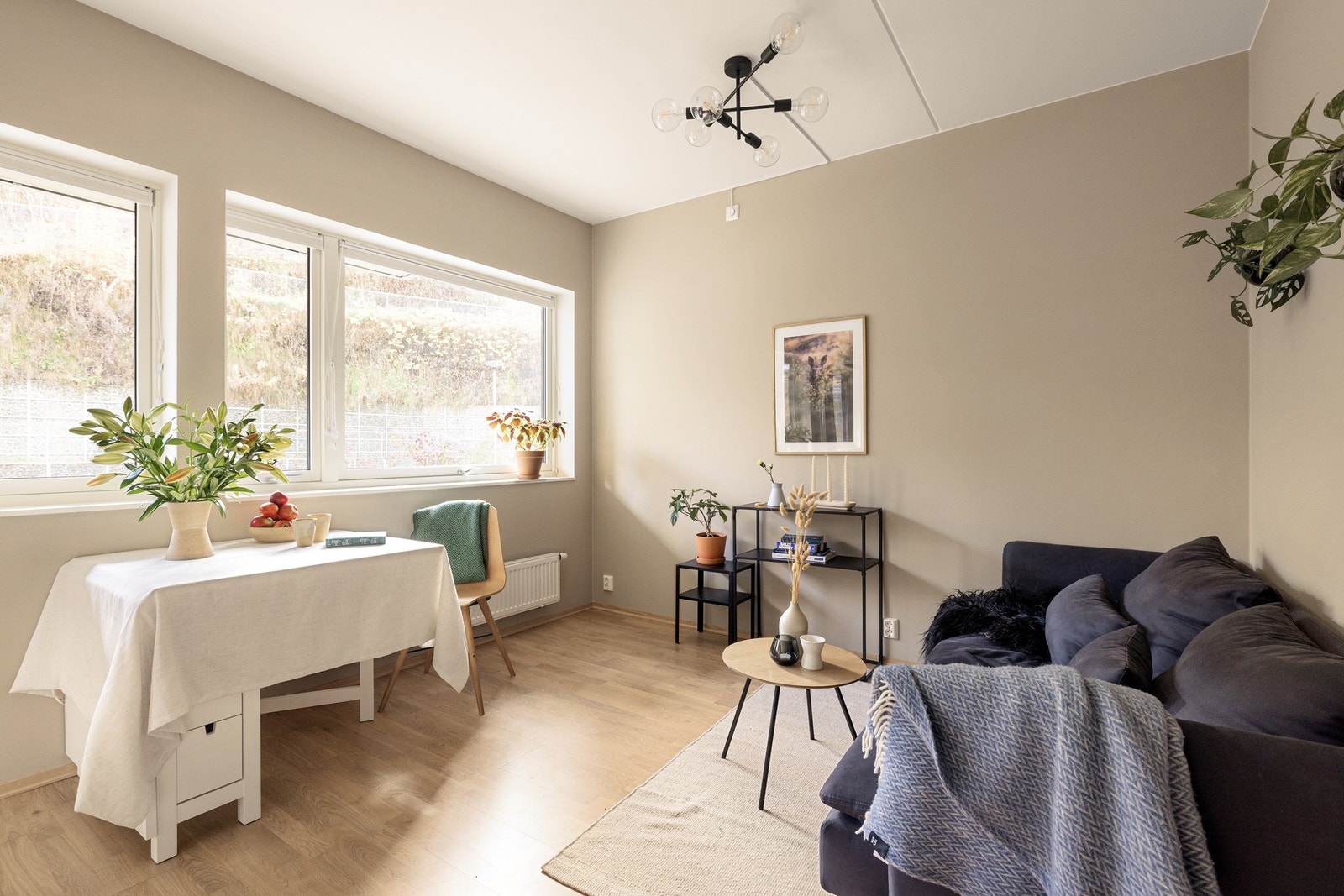 Leiligheten har en lys stue med plass til både sofaløsning og spisebord. Galleribilde