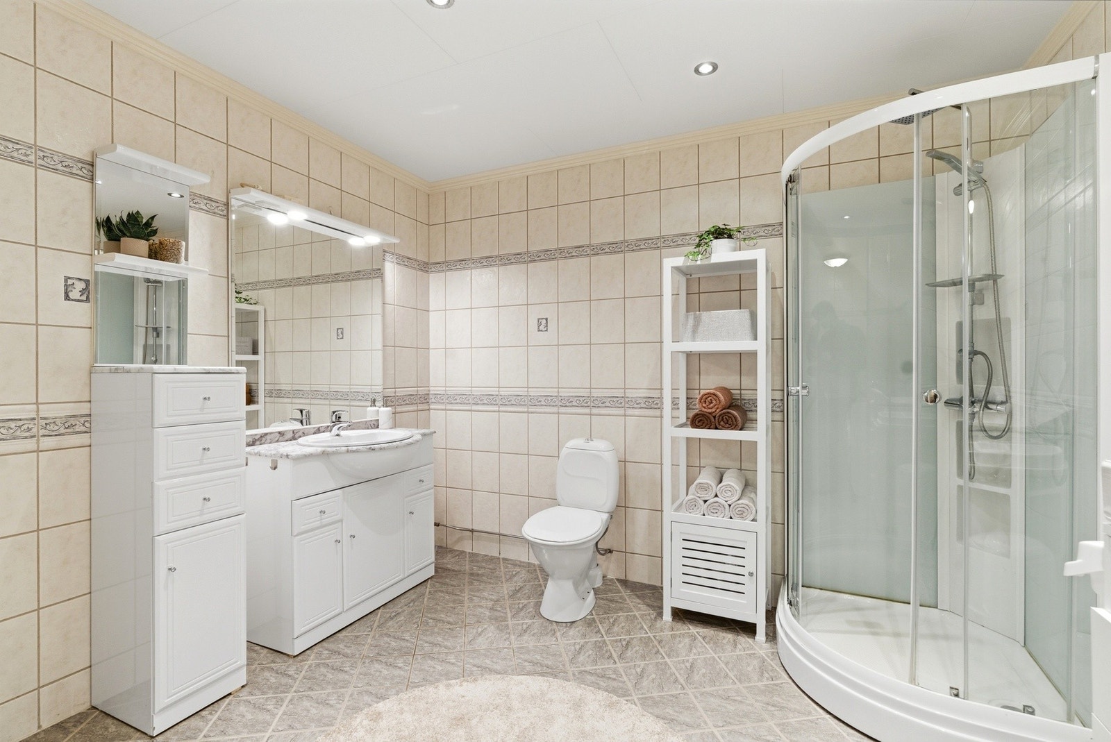 Romslig og pent flislagt bad med varmekabler i gulvet. Galleribilde