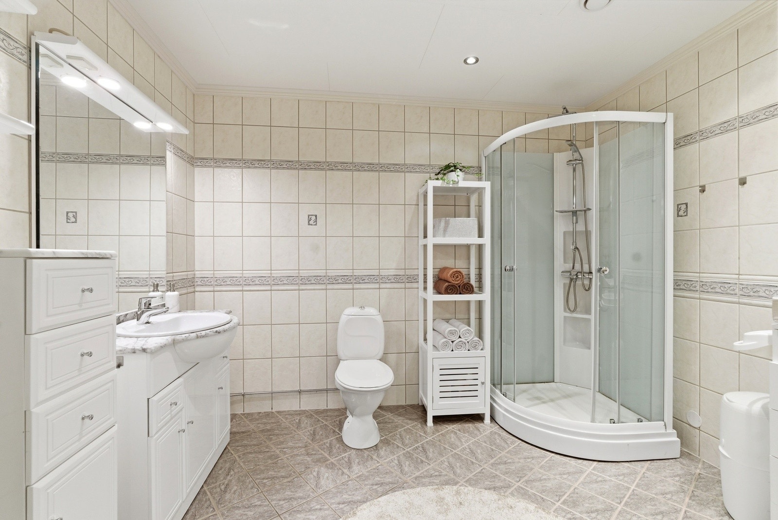 Innredning med nedfelt servant, toalett, dusjkabinett og opplegg for vaskemaskin. Galleribilde