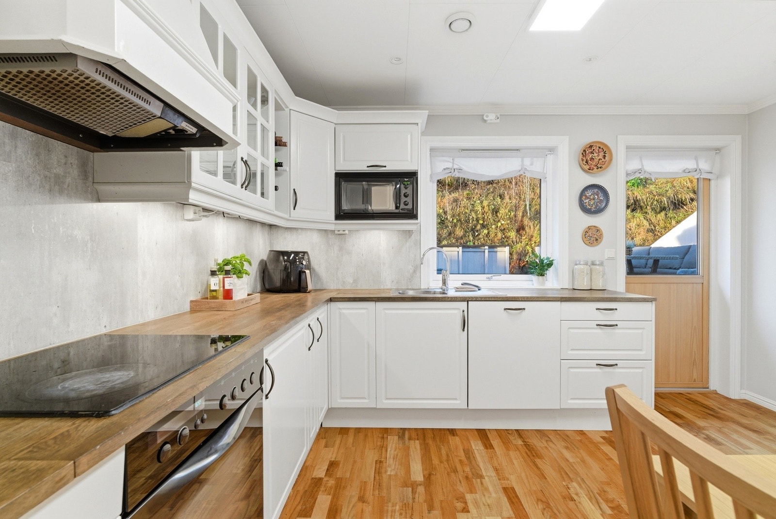 Kjøkkenet har innredning med profilerte fronter og benkeplate av heltre. Galleribilde