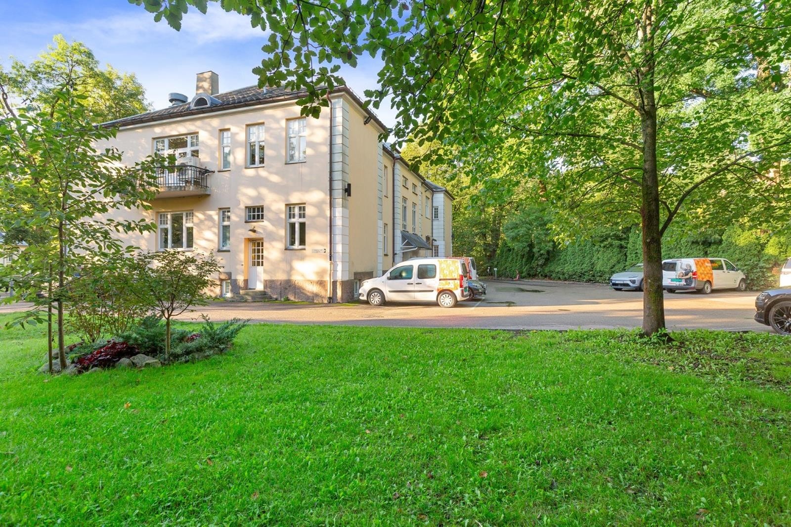 Pent opparbeidet beplantning i innkjørselen til parkeringsplassene utenfor inngangspartiet. Galleribilde