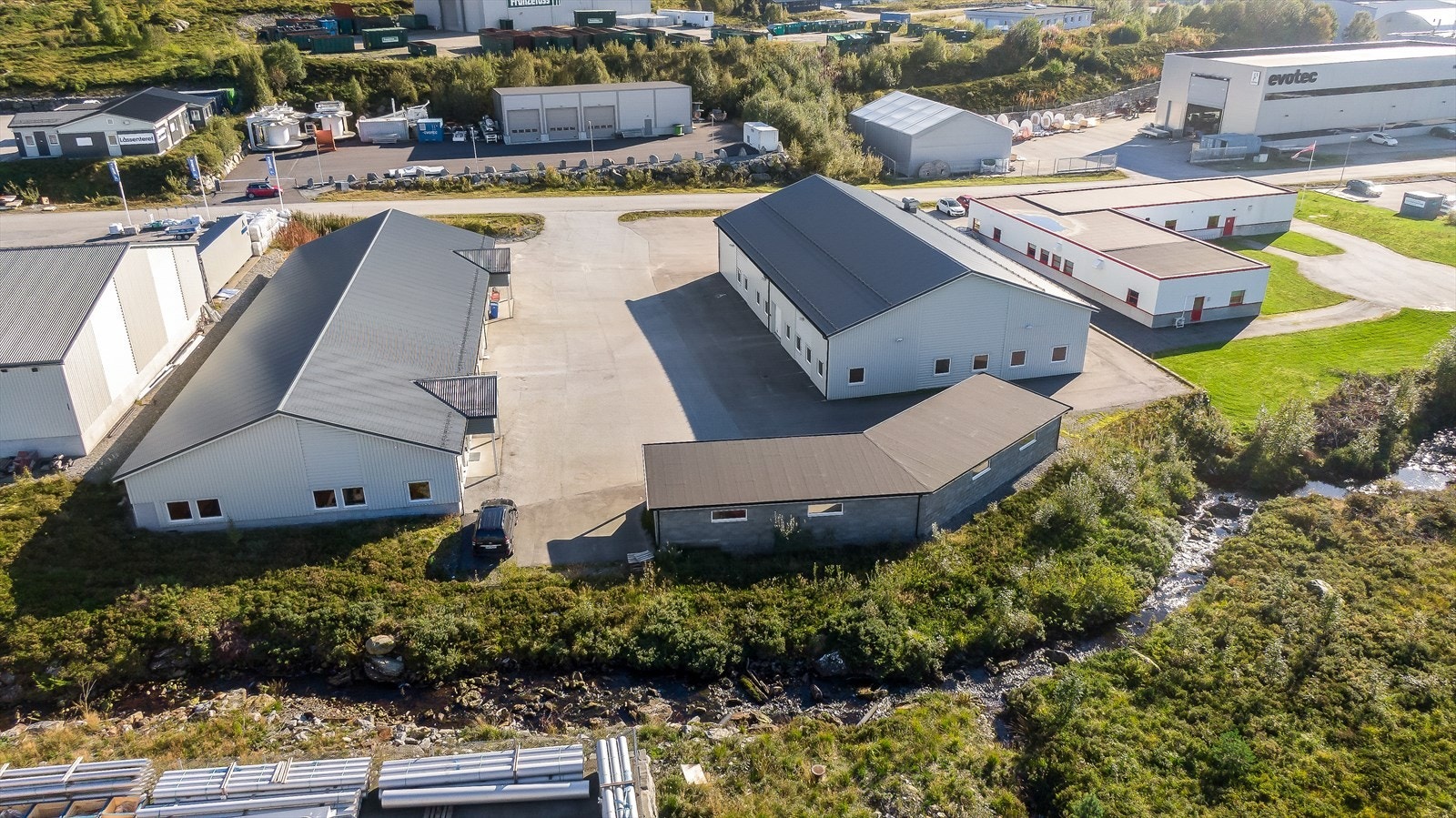 003_På baksida av eigedomen med tilhøyrande carportanlegg med ca 10 p.plasser for bil.jpg Galleribilde