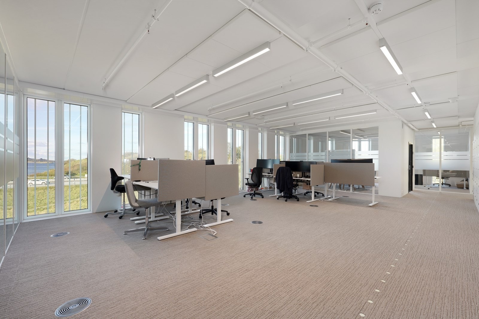 Lyst og moderne kontorlokale med store vinduer, naturskjønn utsikt og fleksible arbeidsområder. Perfekt for en dynamisk arbeidsplass. Galleribilde