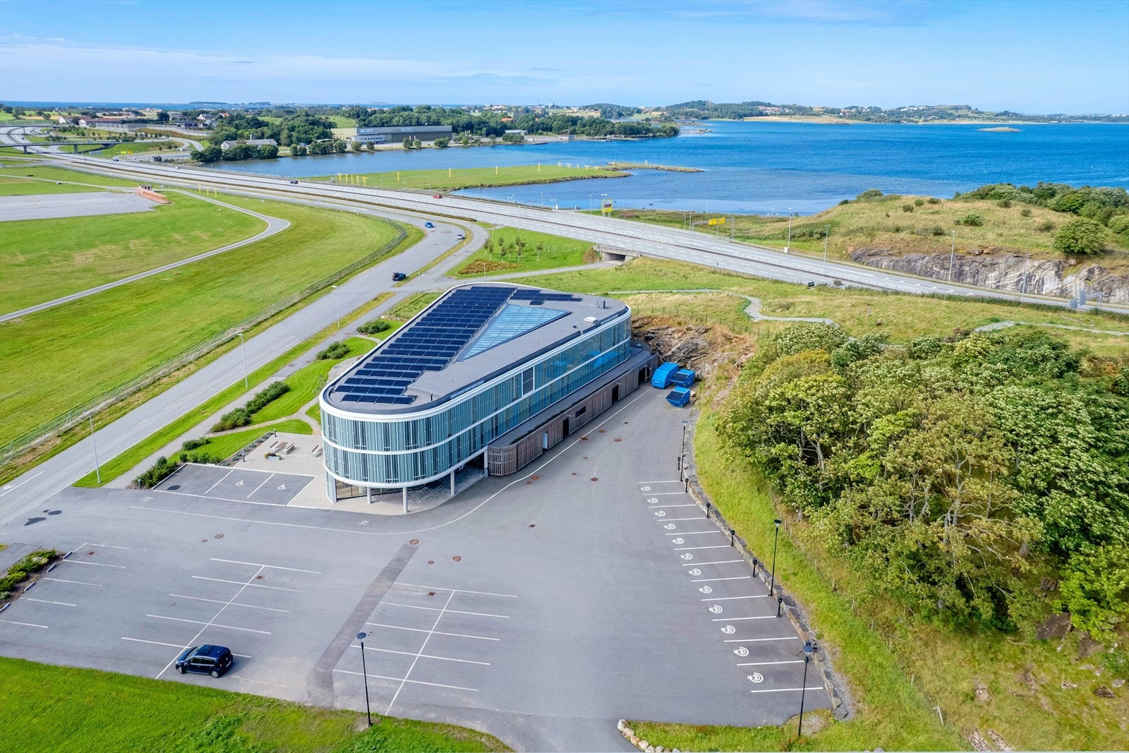 Moderne kontorbygg med unik, trekantet design, solcellepaneler, naturskjønn beliggenhet ved sjøen, nær hovedvei. Godt med parkeringsplasser. Galleribilde