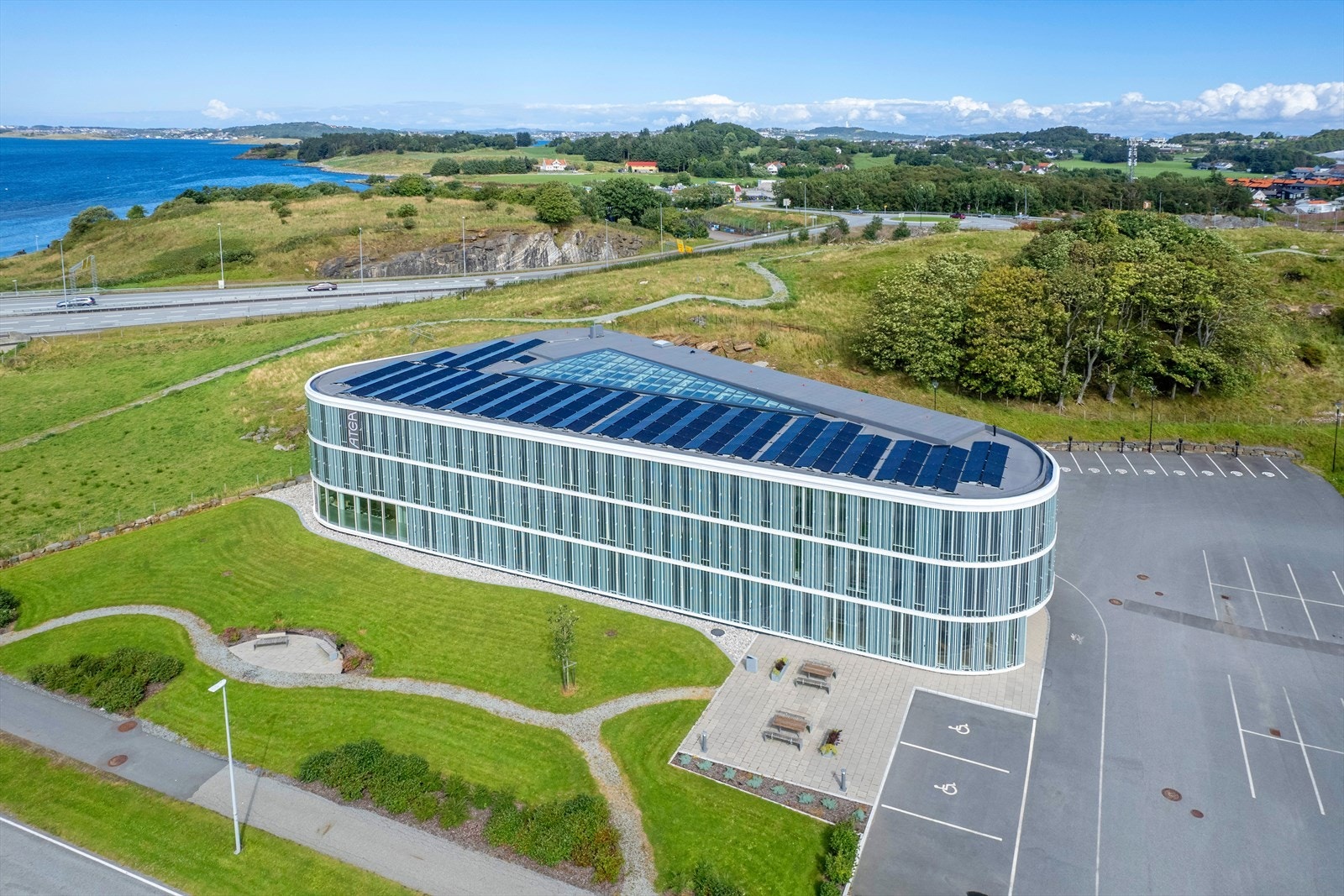 Moderne næringsbygg med solcellepaneler, vakker beliggenhet ved utsikt til sjø, gode parkeringsmuligheter og naturskjønne omgivelser. Ideelt for fremtidsrettede virksomheter. Galleribilde