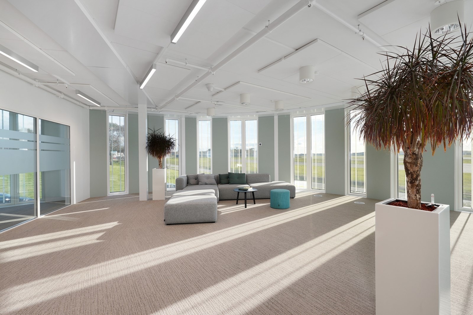 Lys og innbydende stue med store vinduer som gir flott utsikt og naturlig lysinnslipp, perfekt for avslapning og sosiale sammenkomster. Galleribilde