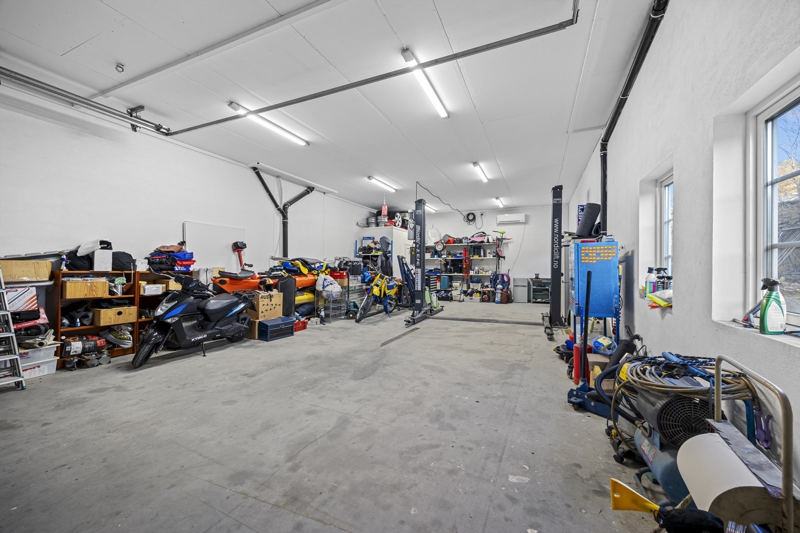 Eiendommen har romslig, isolert garasjeanlegg på grunnplan med god takhøyde (nær 3,4 meter) og bred kjøreport, velegnet til lagring og vedlikehold av kjøretøy. Galleribilde