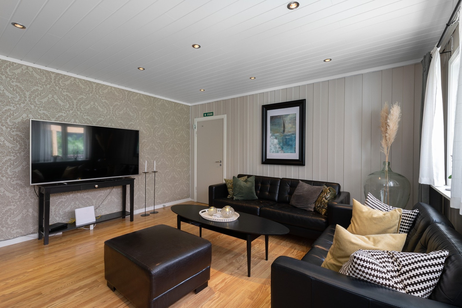 Stuen har en stilig tapet og panel malt i tidsriktige farger. Galleribilde