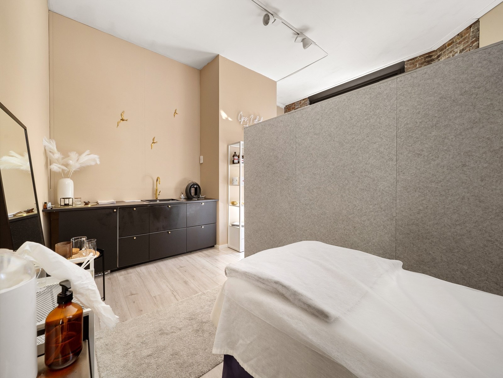 Sort kjøkken med slette fronter, benkeplate av laminat, vask og kjøleskap. Galleribilde