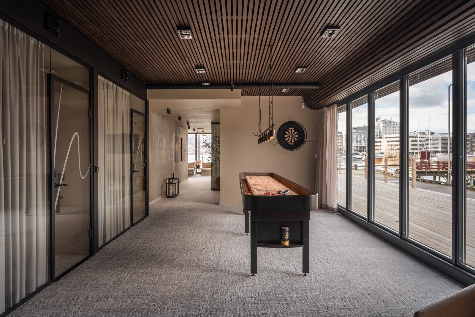 Midt i lokalet finnes det en sosial sone, i dag innredet med shuffleboard Galleribilde