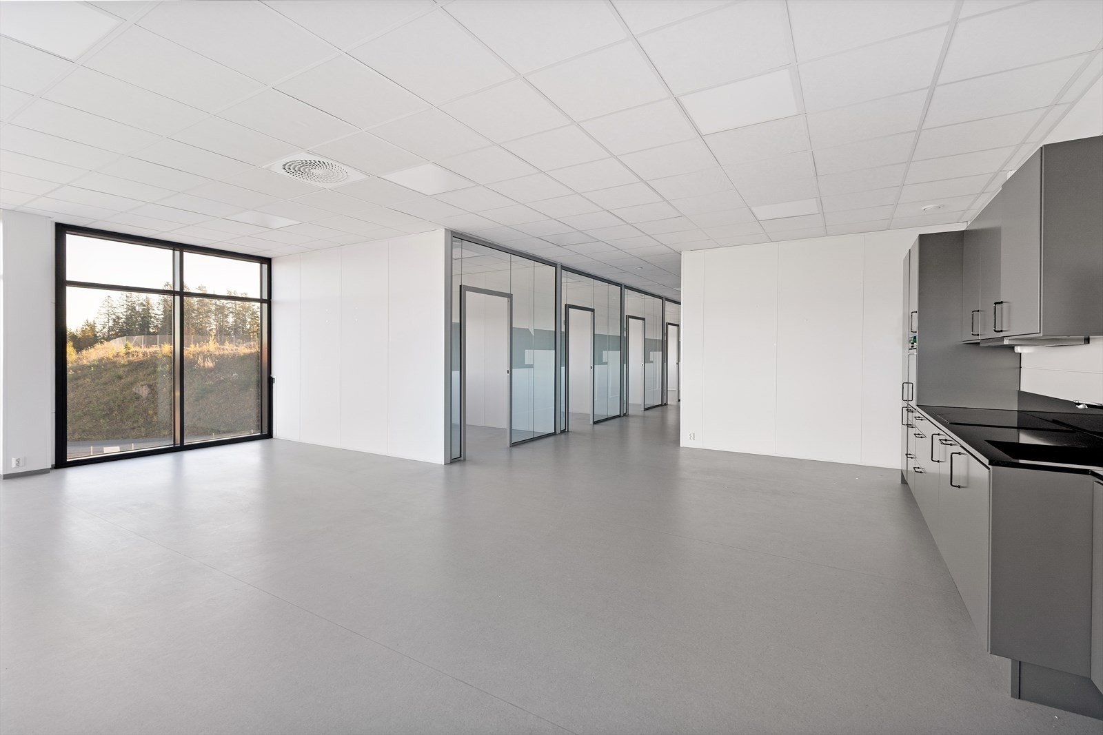 Lyst og romslig lokale med store vinduer og flere kontorer Galleribilde