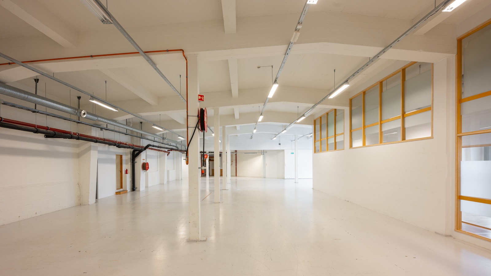 Lyst og åpent areal med hele 5,2 meter fri takhøyde og godt lysinnslipp Galleribilde