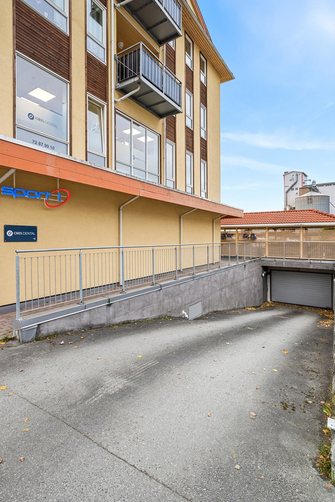 Det er innkjøring til parkeringskjelleren langs siden av bygget. Galleribilde