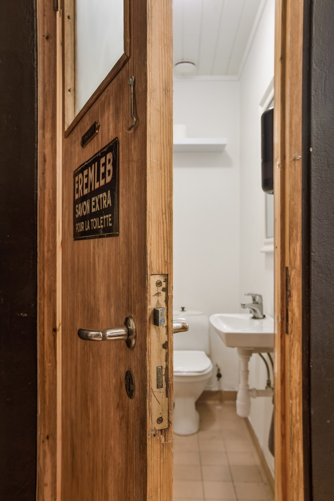 Toalett med flislagt gulv, innredet med toalett og servant. Galleribilde