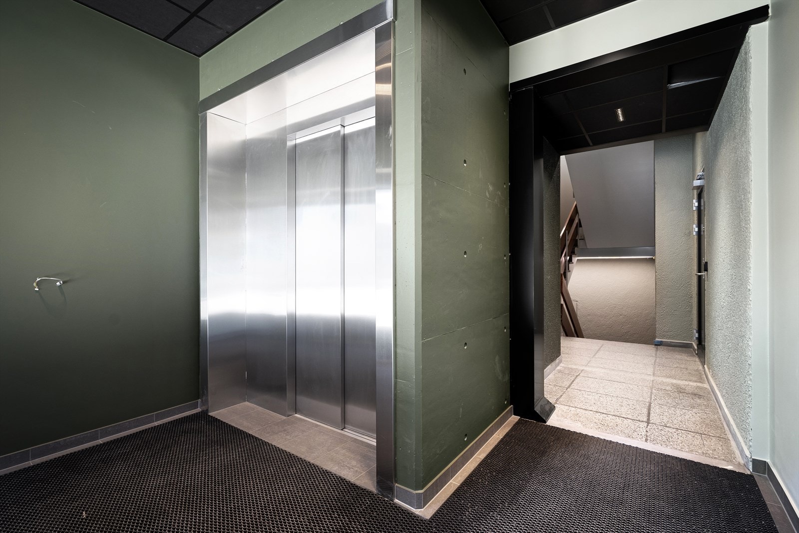 Inngangsparti, heis med plass til sykkel. Sykkelparkering i kjelleren. Galleribilde